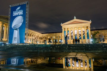 the Philadelphia art Museum with celabratory banner and sill water relection on the ground